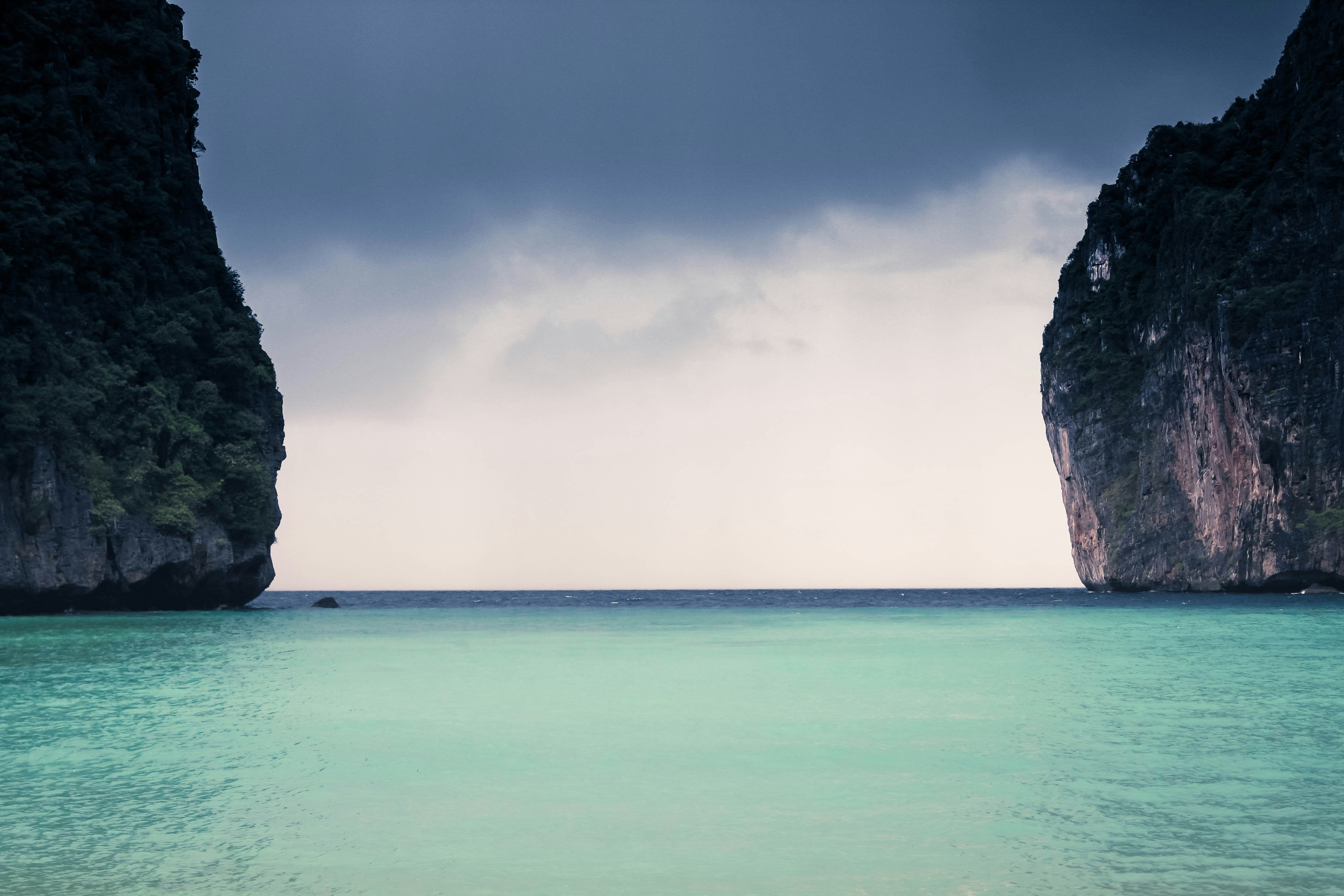 body of water with of two rock formations during daytime